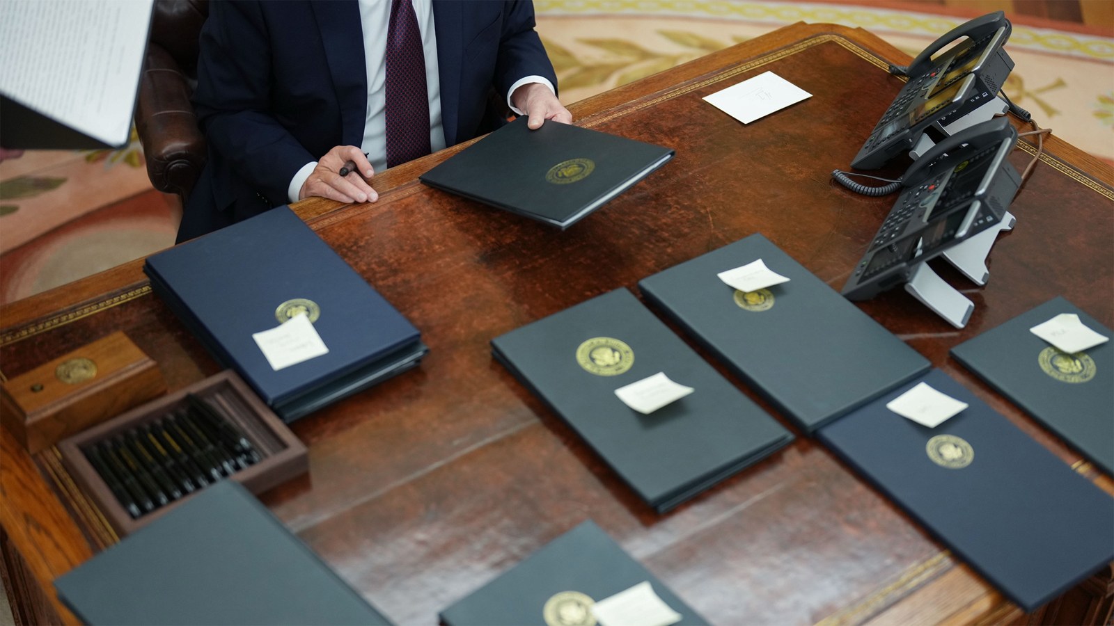 Executive orders in folders on the Resolute Desk